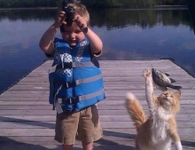 A boy and his cat catching some fish together.