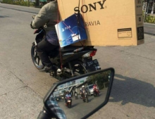 Sony PS4 and Sony 50 inch TV strapped to the back of a motorcycle. Sony should buy this guy a car.