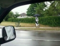 Stormtrooper riding a unicycle in the rain.