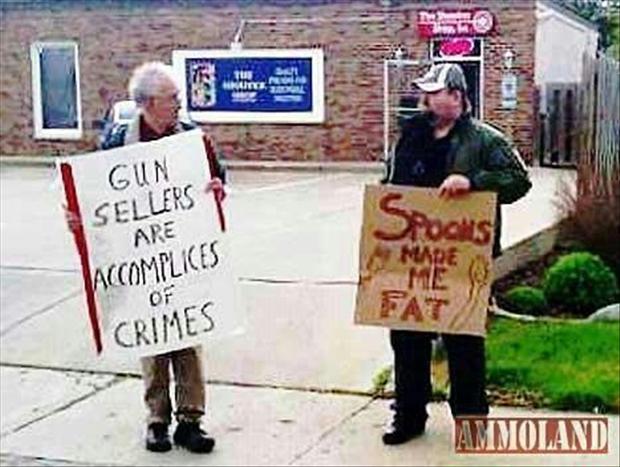 Man protesting against gun dealers is joined by another man who gives him something to think about.