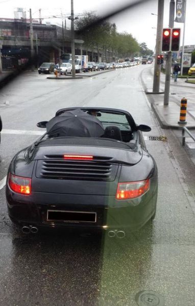 Driving a Porsche Convertible in the rain with the top down is no problem for this driver.