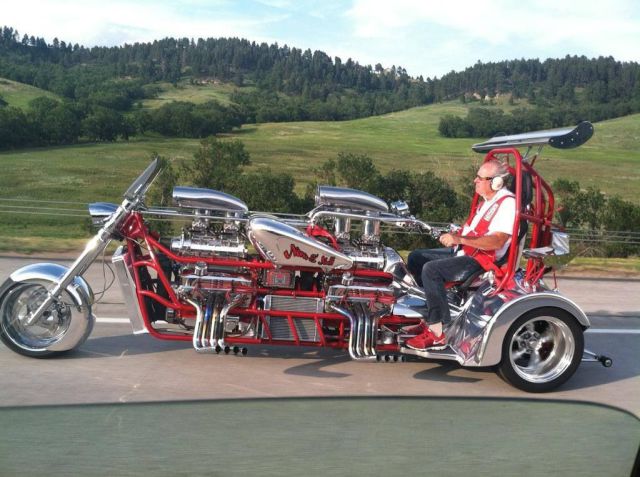 Extended trike with two blown V-8 engines, wheelie bar, dual rear wings, roll bar, and he doesn't even buy matching ear muffs.