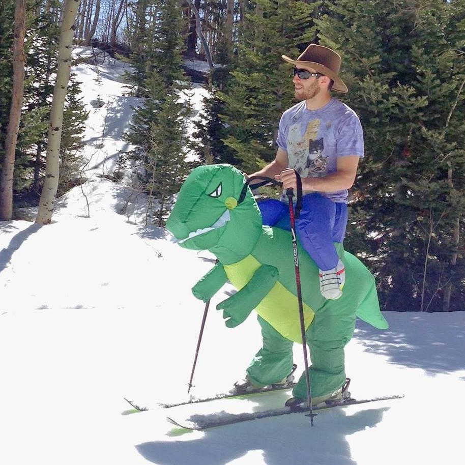 Snow skiing on the back of a Tyrannosaurus Rex.