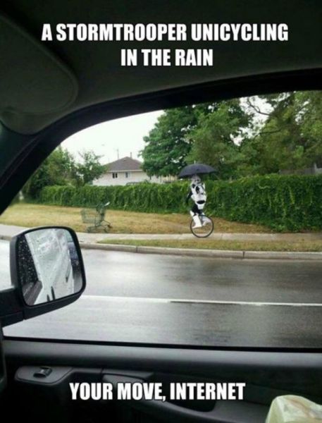 Stormtrooper riding a unicycle in the rain.