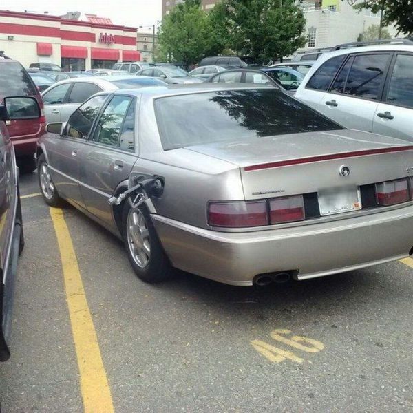The Driver Of This Cadillac Sucks At Parking And From The Looks Of It Not Very Good At Getting Gas Either.