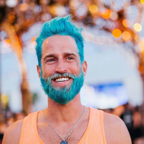There is a new fad happening where men dye their hair and beards vibrant colors. This guy is going for the Smurf look.