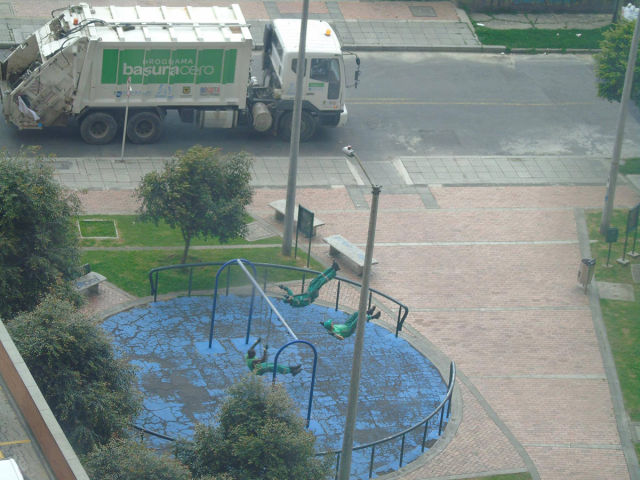 These garbage men decided to take a break and have a little fun on some playground swings.