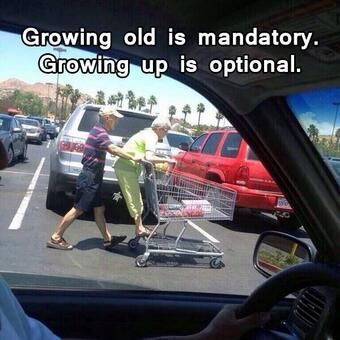 An older couple having some fun on a trip to the store by riding on the cart like everyone did as a child.