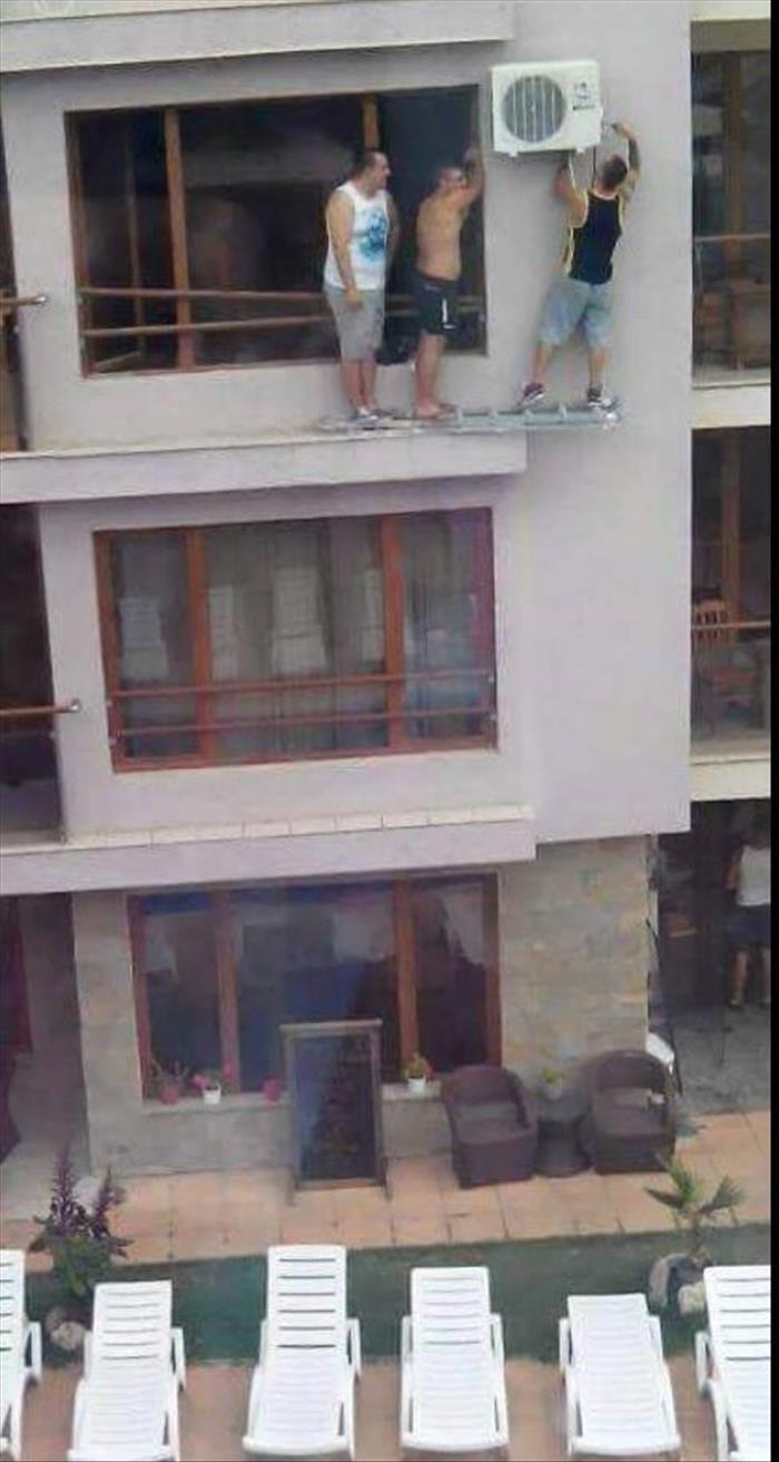 3 guys using a ladder for some precarious home repair. Do not try this at home.