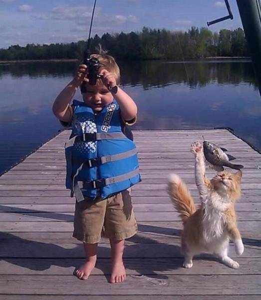 A boy and his cat catching some fish together.