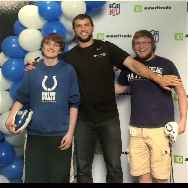 Andrew Luck takes a picture with a Colts fan and a Patriots fan.