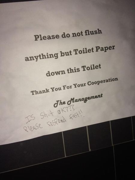 Confusing sign in a public bathroom toilet stall has the user confused and having to deal with a major dilemma.