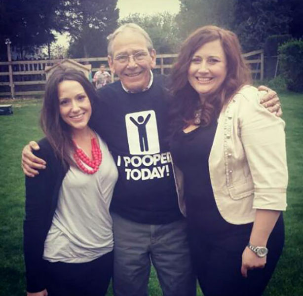 Father celebrating with his two proud daughters after his huge accomplishment.