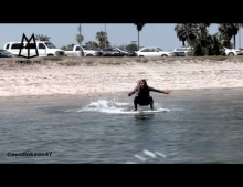Dude catches a ride on a passing boats wake.