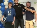 Andrew Luck takes a picture with a Colts fan and a Patriots fan.