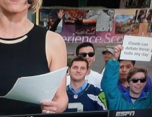 Man holds up sign during live ESPN sportscast with an offer for Tom Brady's beautiful wife Gisele Bündchen.