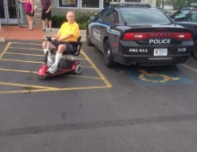 Man in mobility scooter finds a great photo op when a cop car parks in a handicap spot at an IHOP restaurant.