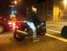 Motorcycle rider wearing rollerblades. It must be hard to shift but fun at stop lights.