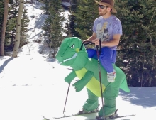 Snow skiing on the back of a Tyrannosaurus Rex.