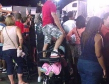 Standing on top of a baby stroller with your child in it to get a better view shows a priority problem.