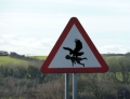 This large birds snatching up children warning sign is creepy.