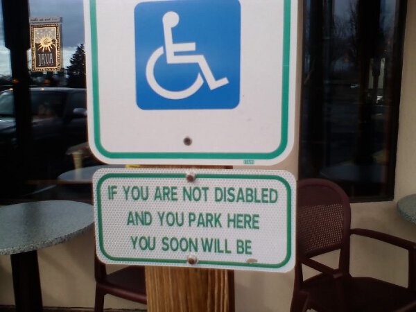 This handicapped parking sign comes with a fair warning.